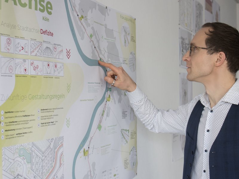 Alexander Heber zeigt etwas auf einem Plan.